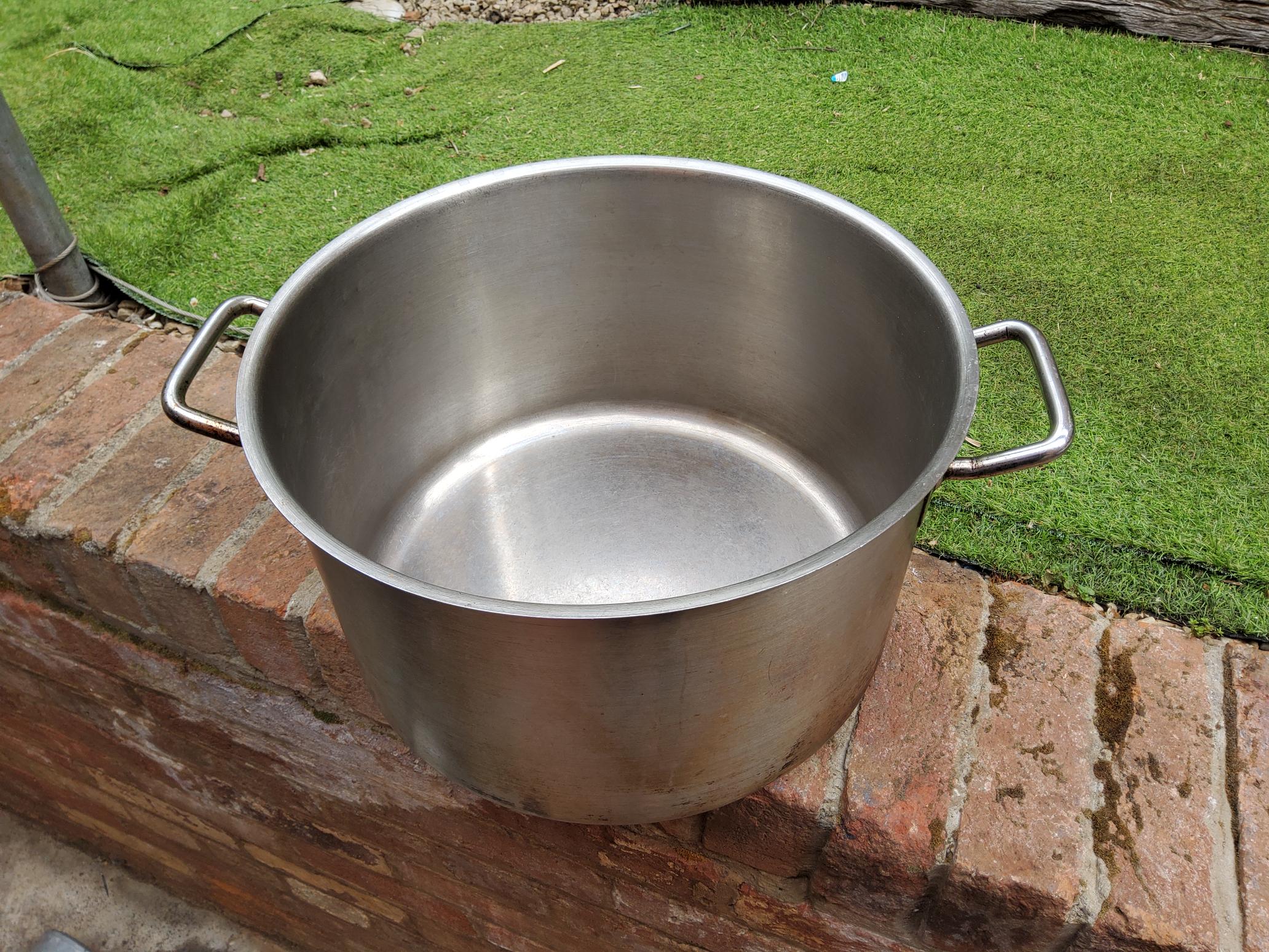 A large empty cooking pot situated outdoors.