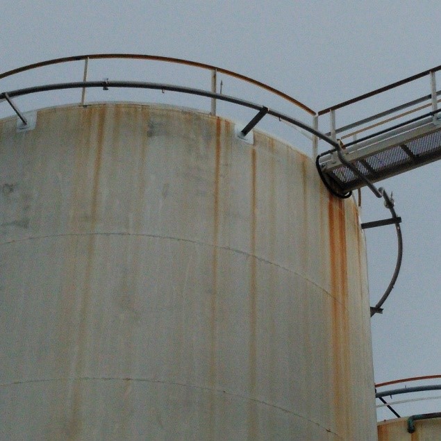 Bulk storage tank with corrosion showing location of leak adjacent to the walkway.